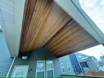 Covered patio roof with wooden ceiling boards and beams by DreamDecks