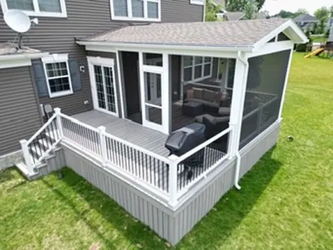Composite deck with white railing and lower level patio by DreamDecks