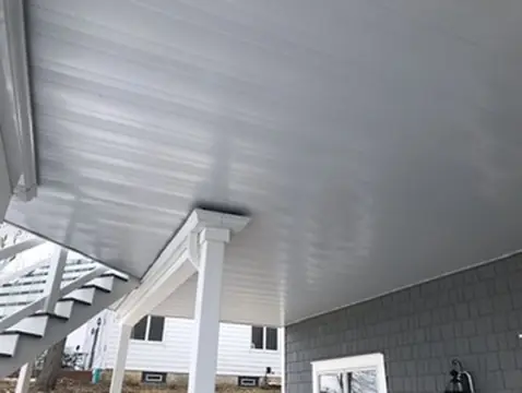 Covered deck ceiling with white beams and recessed lighting by DreamDecks