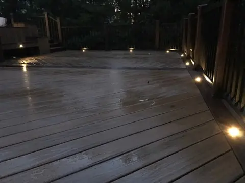 Completed composite deck with dark boards after rain by DreamDecks
