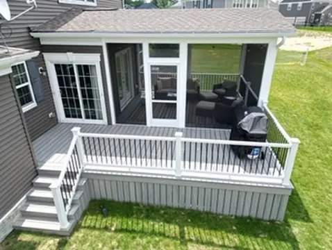 Front porch with white railings and columns at home by DreamDecks