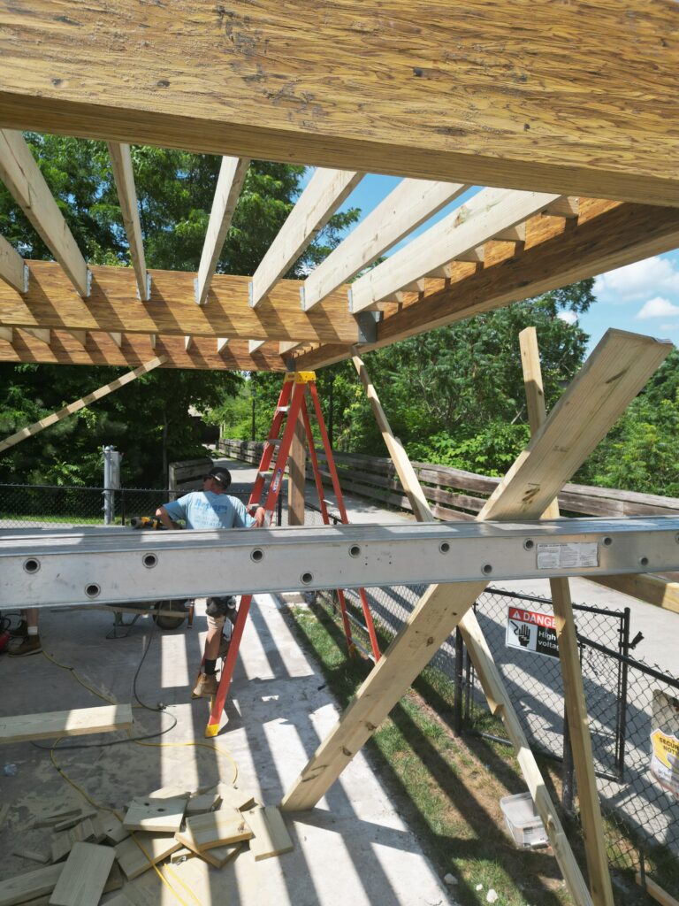 Aerial view of a custom wooden deck with outdoor seating and pergola in a Northeast Ohio backyard
