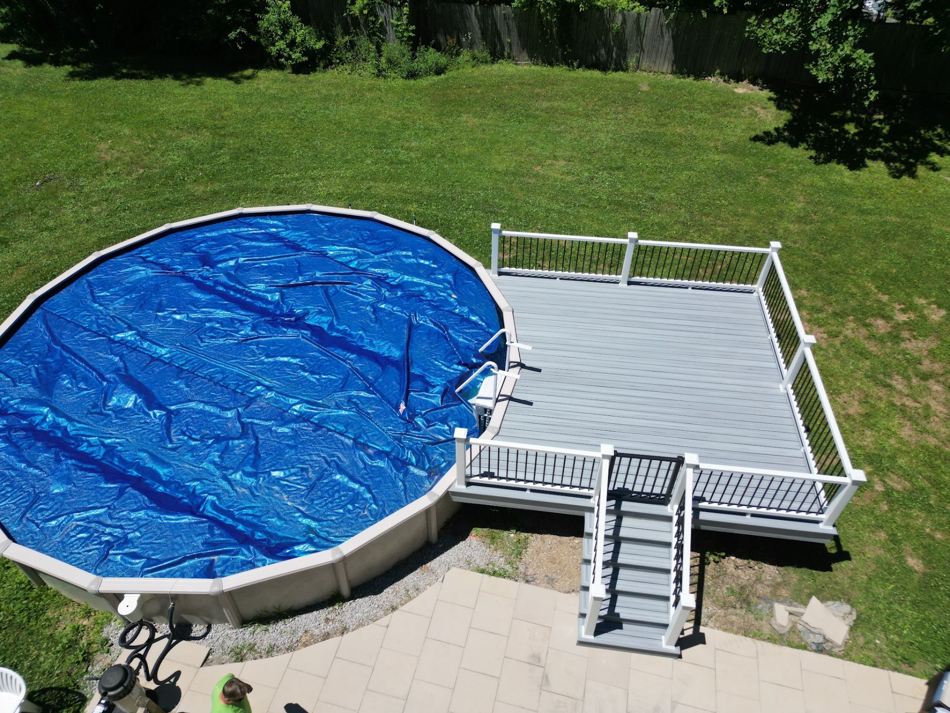 Composite deck with white railing and stairs built around an above ground pool by DreamDecks in Northeast Ohio