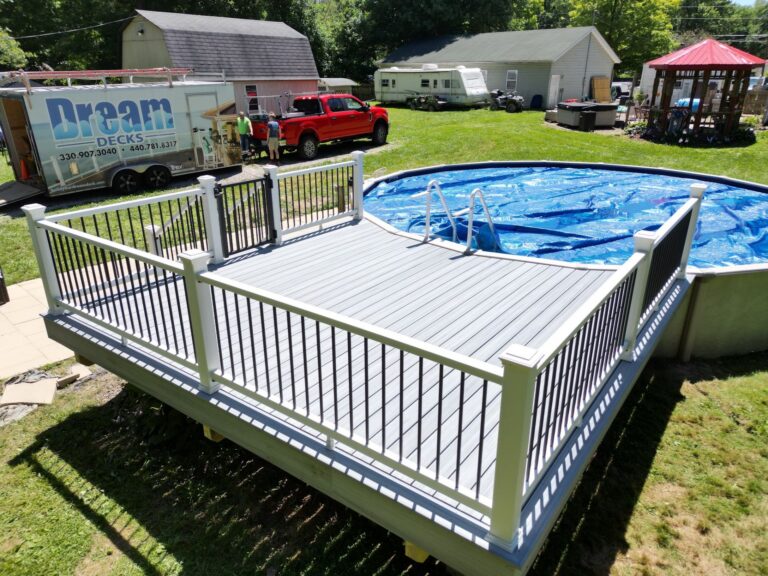 Composite deck with white railing and stairs built around an above ground pool by DreamDecks in Northeast Ohio