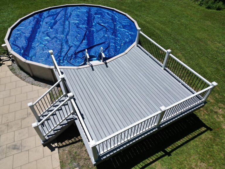 Composite deck with white railing and stairs built around an above ground pool by DreamDecks in Northeast Ohio