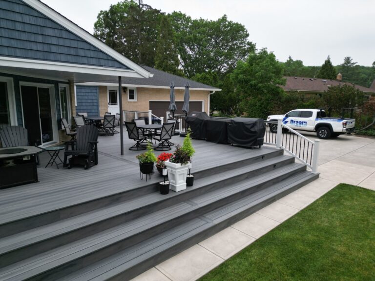 Wide composite deck stairs leading to a wraparound deck, built by DreamDecks in Northeast Ohio