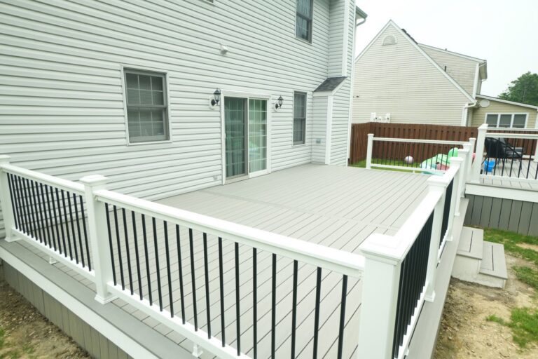 Gray composite wraparound deck with white railing next to an above ground pool, built by DreamDecks in Northeast Ohio