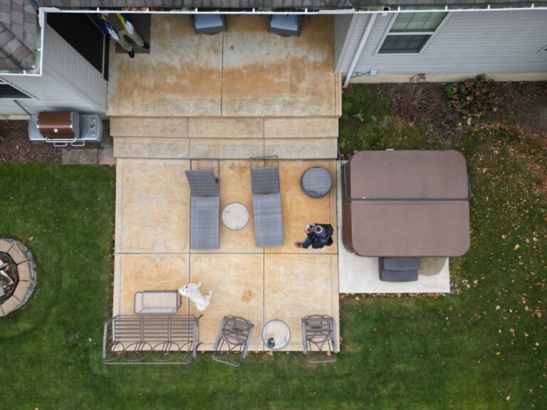 Aerial view of an old concrete patio and hot tub before DreamDecks built a composite deck over it
