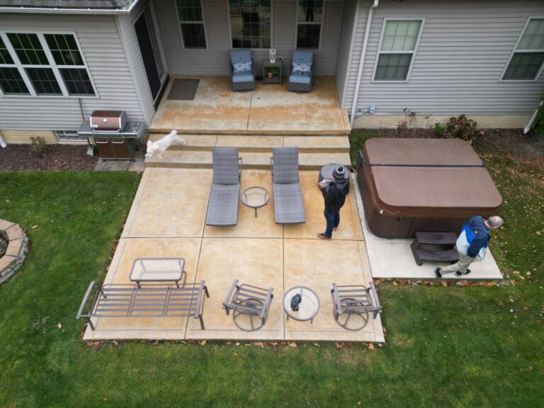 Aerial view of an old concrete patio and hot tub before DreamDecks built a composite deck over it