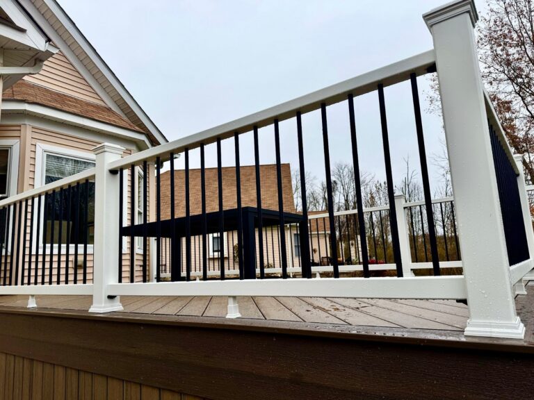 Covered composite deck with a vaulted white ceiling, ceiling fan, and lights, built by DreamDecks in Hudson, Ohio