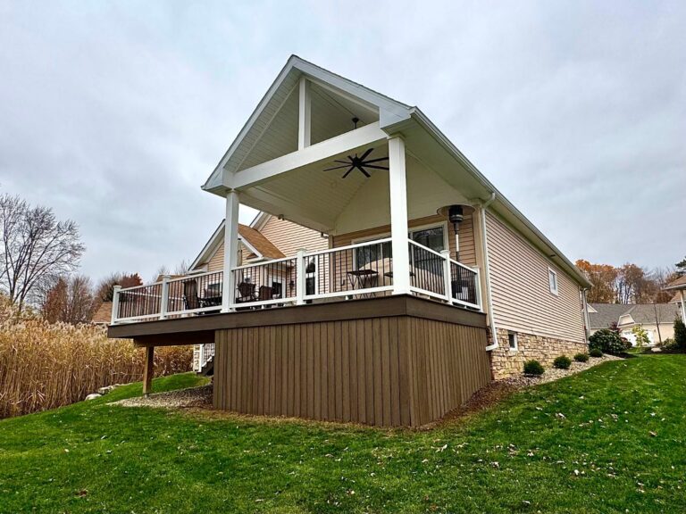 Covered composite deck with a vaulted white ceiling, ceiling fan, and lights, built by DreamDecks in Hudson, Ohio