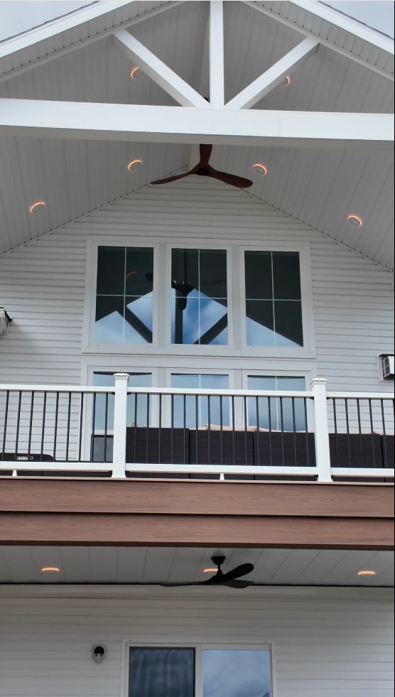 White cathedral ceiling with exposed trusses, recessed lights and a ceiling fan over a Trex Lineage Carmel deck with white Trex Select railing in Richfield Ohio