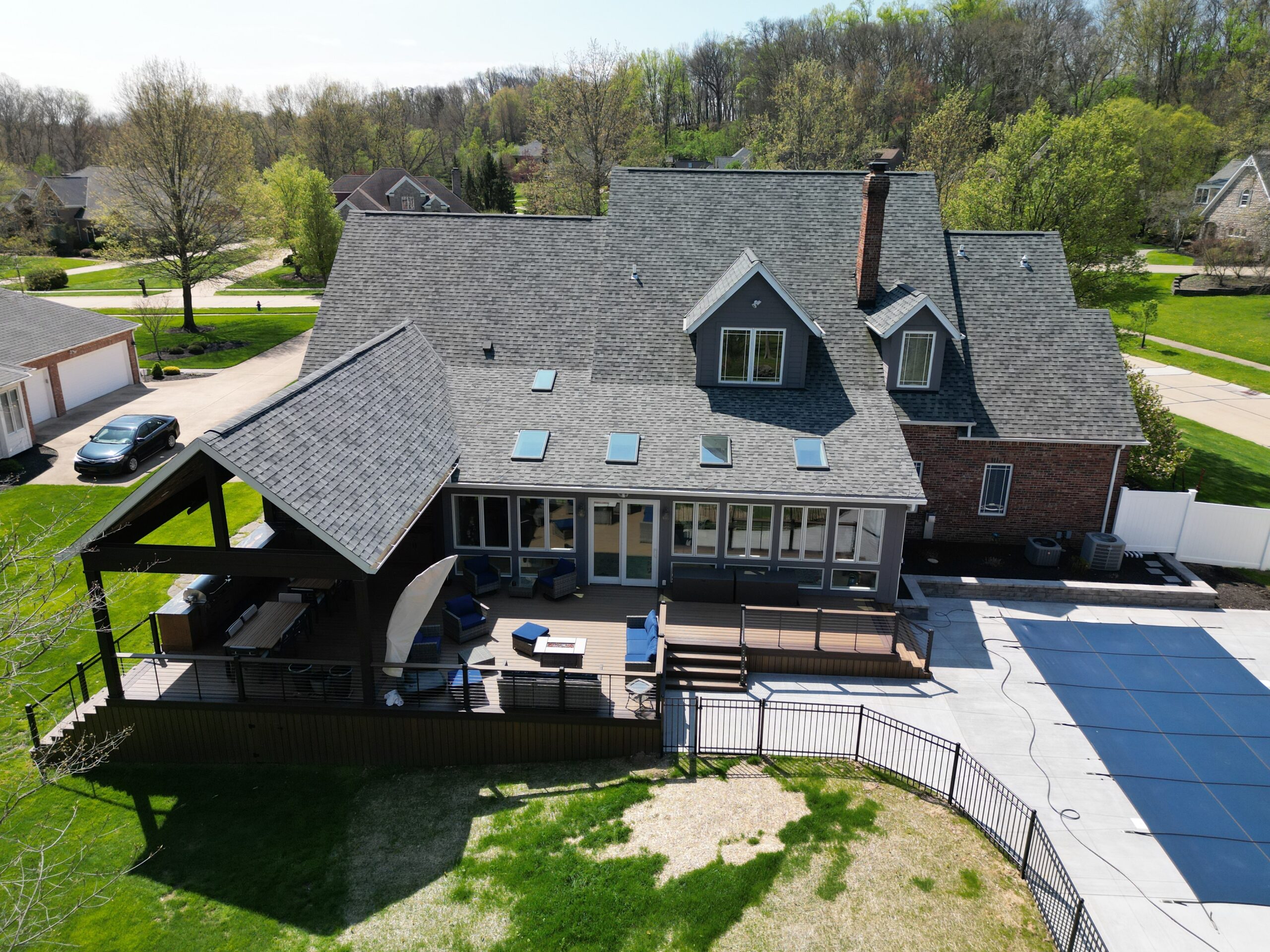 The finished deck, covered roof, and outdoor kitchen next to the pool