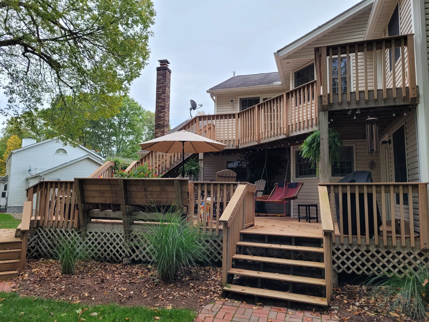 Original wood deck with lattice skirting and wood railings before the resurface